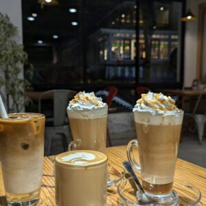 Assorted coffee drinks on a wooden table in a cozy café, perfect for a relaxing break.